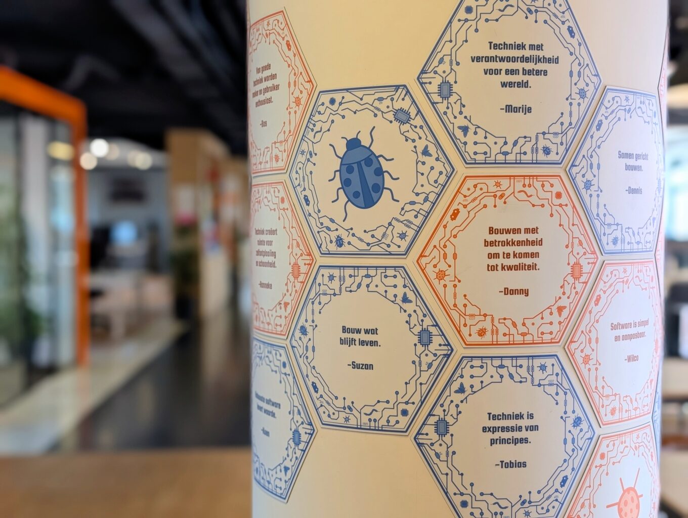 Pilaar met handvol hexagon magneten erop. Blurry kantoor op de achtergrond.