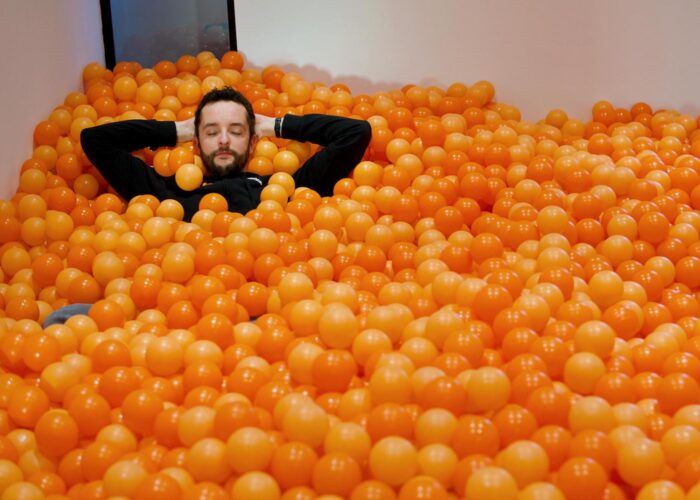 Hoofd en armen persoon. Persoon omringt door oranje ballen.