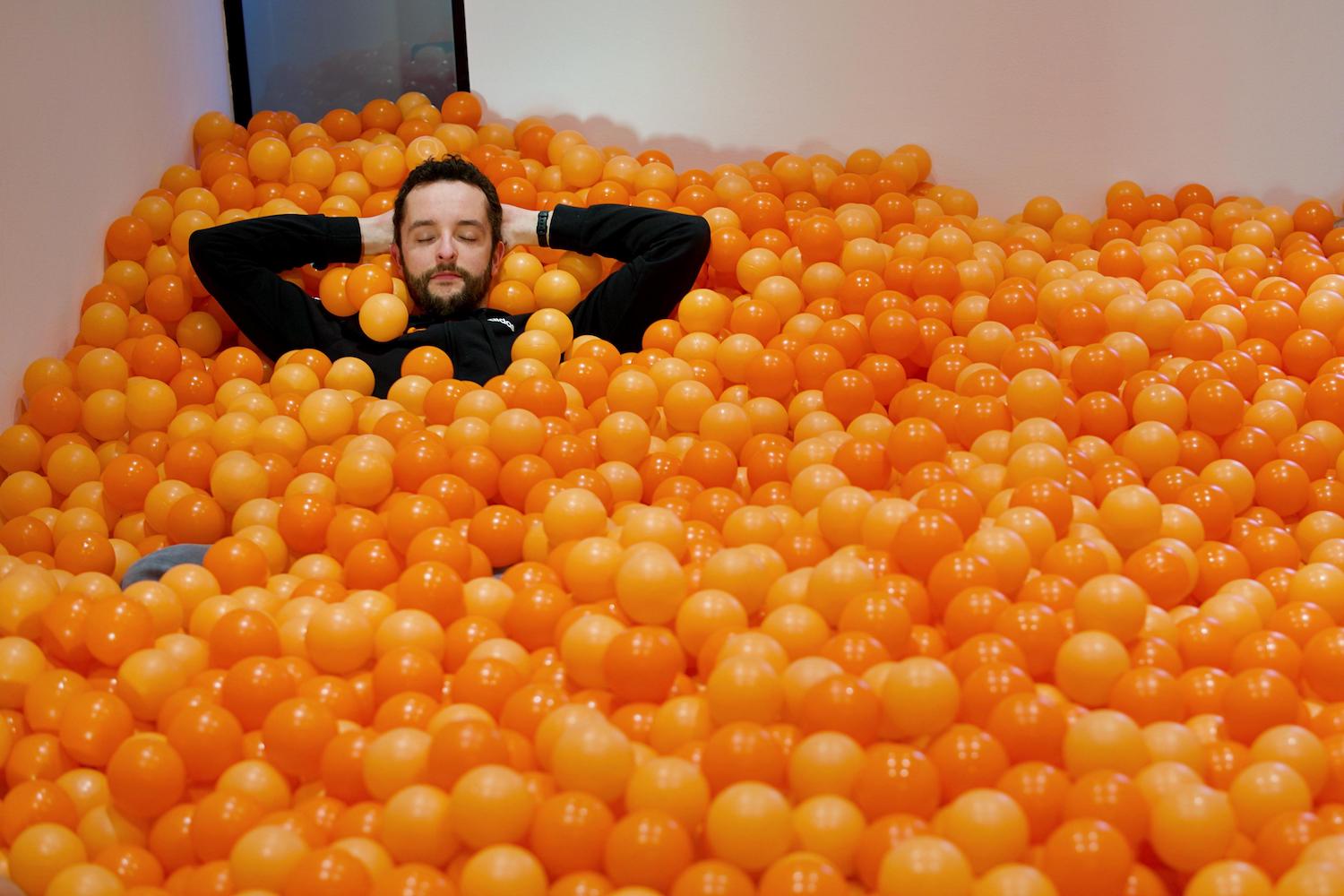 Hoofd en armen persoon. Persoon omringt door oranje ballen.